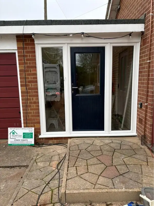 Dark blue glazed door with full-height side windows in a white uPVC frame. Installed by Norfolk Exterior Solutions.